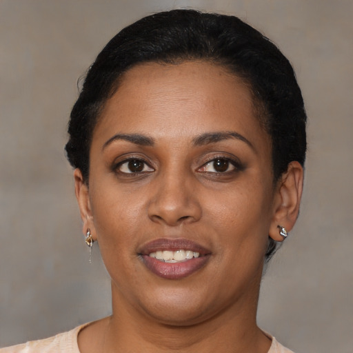 Joyful black young-adult female with short  brown hair and brown eyes