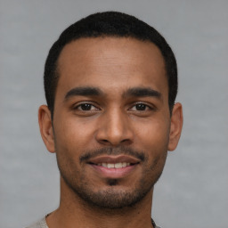 Joyful latino young-adult male with short  black hair and brown eyes