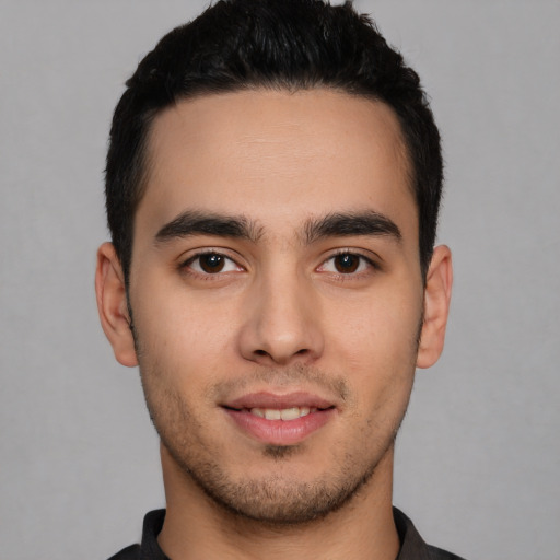 Joyful white young-adult male with short  black hair and brown eyes