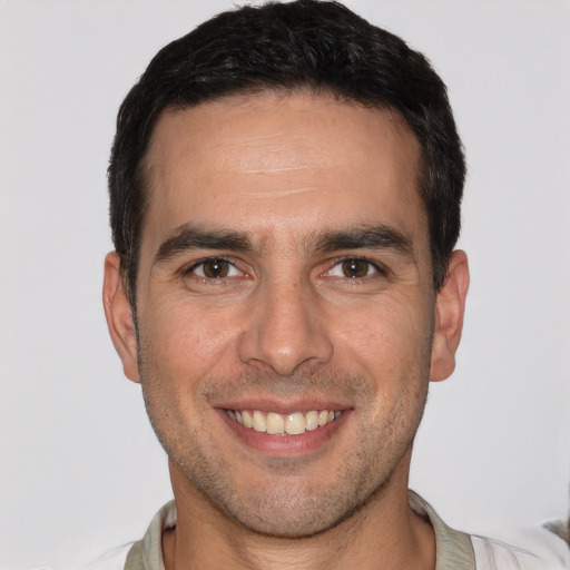 Joyful white young-adult male with short  brown hair and brown eyes