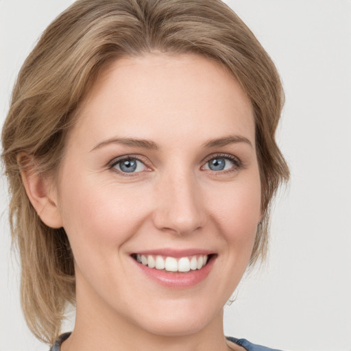 Joyful white young-adult female with medium  brown hair and blue eyes