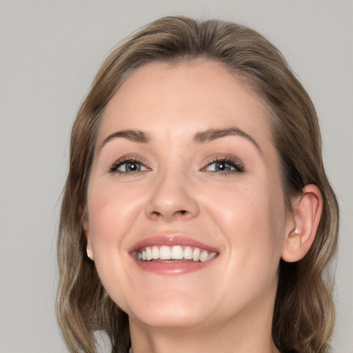 Joyful white young-adult female with medium  brown hair and grey eyes