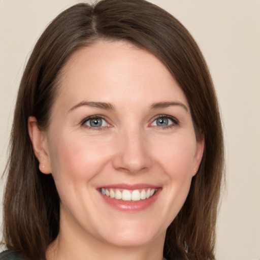 Joyful white young-adult female with medium  brown hair and grey eyes