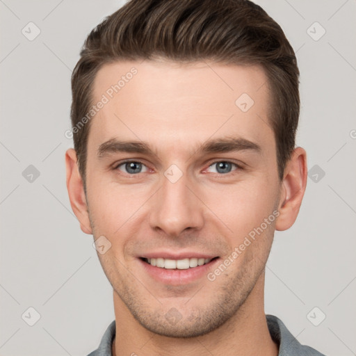 Joyful white young-adult male with short  brown hair and grey eyes