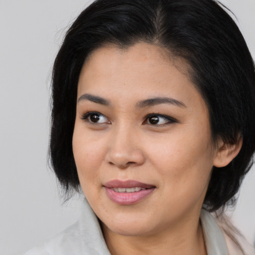 Joyful asian young-adult female with medium  brown hair and brown eyes