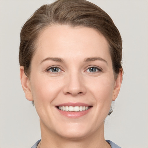 Joyful white young-adult female with short  brown hair and grey eyes