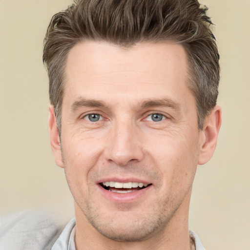 Joyful white adult male with short  brown hair and grey eyes