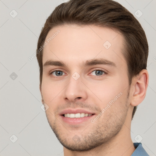 Joyful white young-adult male with short  brown hair and grey eyes