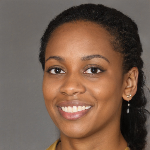 Joyful black young-adult female with long  black hair and brown eyes