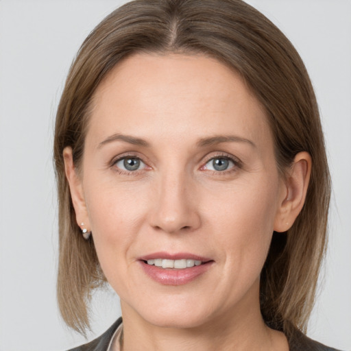 Joyful white adult female with medium  brown hair and grey eyes