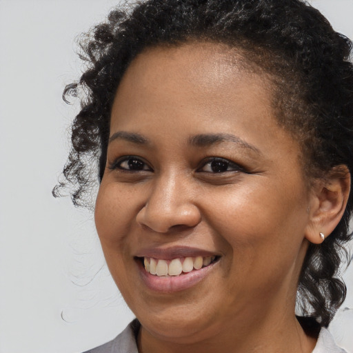 Joyful black young-adult female with medium  brown hair and brown eyes