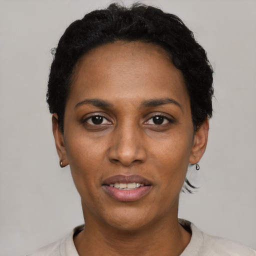 Joyful black young-adult female with short  black hair and brown eyes