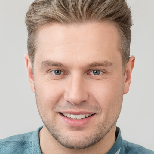 Joyful white young-adult male with short  brown hair and grey eyes