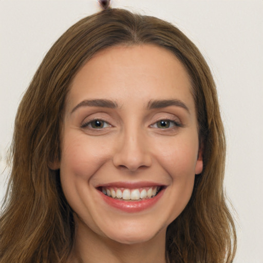 Joyful white young-adult female with long  brown hair and brown eyes