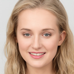 Joyful white young-adult female with long  brown hair and blue eyes