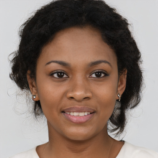 Joyful black young-adult female with long  brown hair and brown eyes