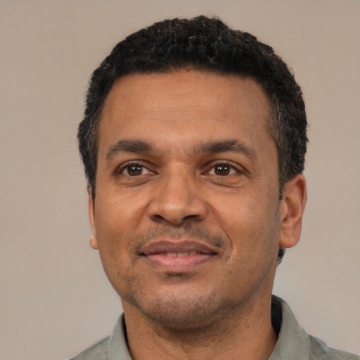 Joyful latino adult male with short  black hair and brown eyes