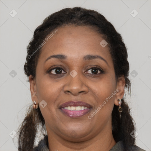 Joyful black adult female with long  brown hair and brown eyes