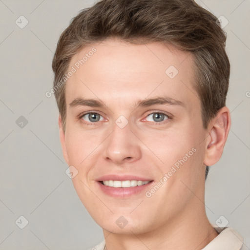 Joyful white young-adult male with short  brown hair and grey eyes