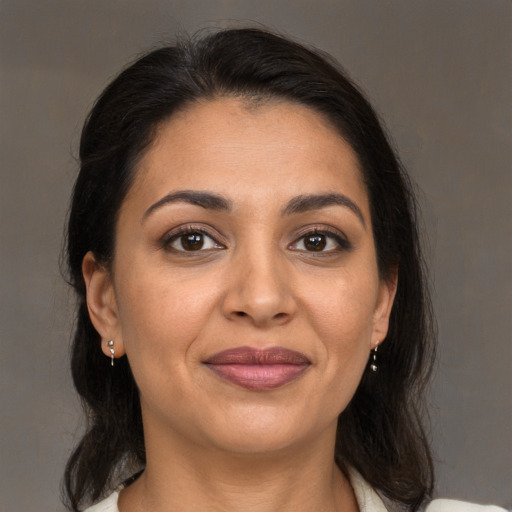 Joyful latino adult female with medium  brown hair and brown eyes