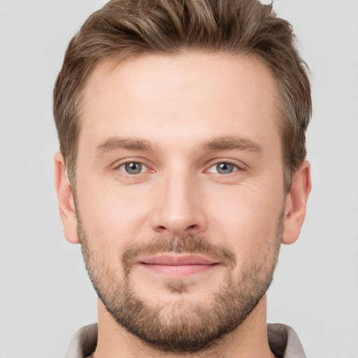 Joyful white young-adult male with short  brown hair and grey eyes