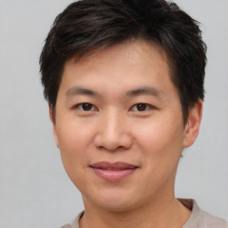 Joyful asian young-adult male with short  brown hair and brown eyes