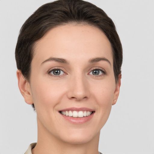 Joyful white young-adult female with short  brown hair and grey eyes