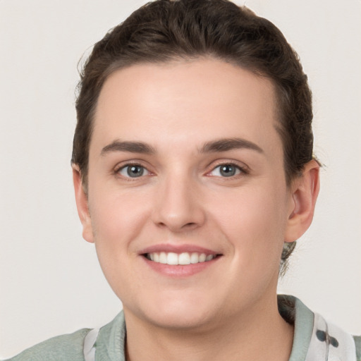 Joyful white young-adult female with short  brown hair and grey eyes