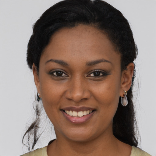 Joyful black young-adult female with long  black hair and brown eyes