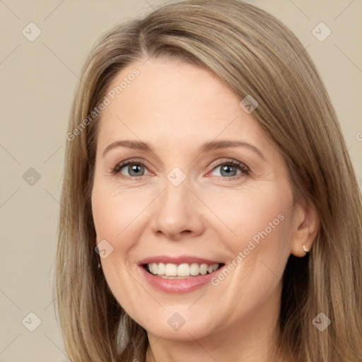 Joyful white adult female with long  brown hair and grey eyes