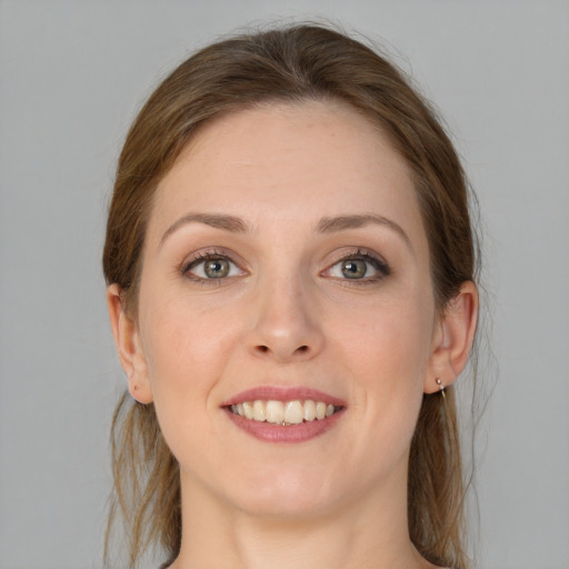 Joyful white young-adult female with medium  brown hair and grey eyes