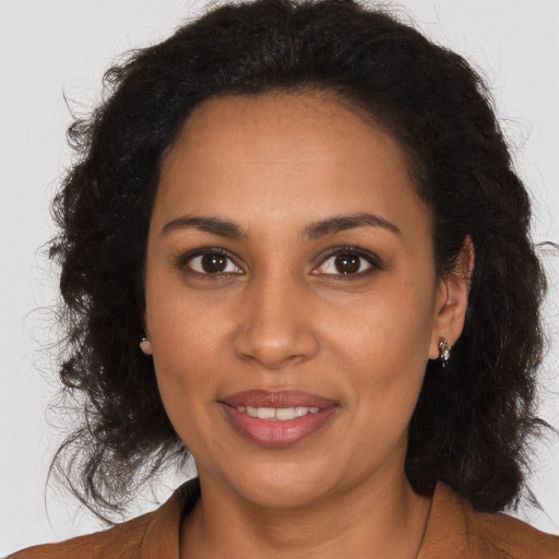 Joyful black young-adult female with long  brown hair and brown eyes