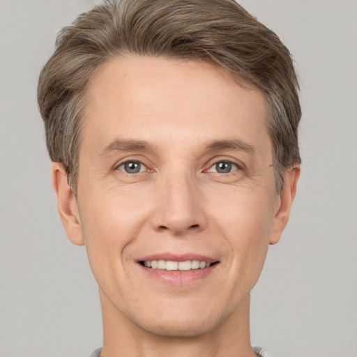 Joyful white adult male with short  brown hair and grey eyes