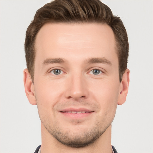 Joyful white young-adult male with short  brown hair and grey eyes