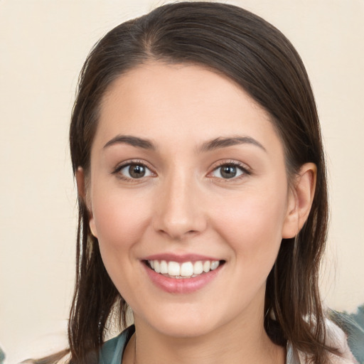 Joyful white young-adult female with long  brown hair and brown eyes