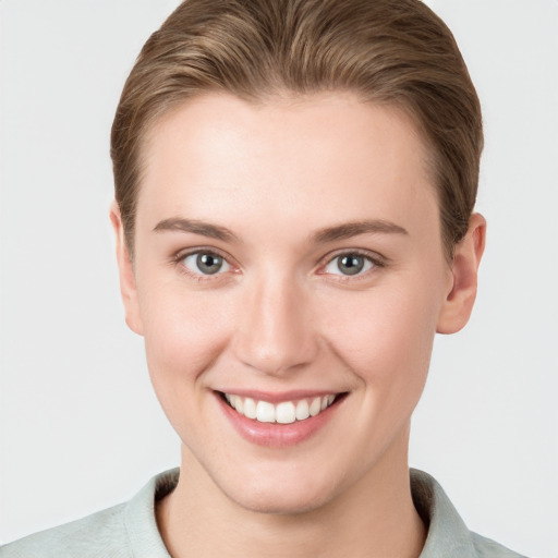 Joyful white young-adult female with short  brown hair and grey eyes