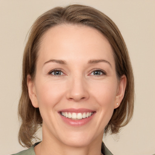 Joyful white young-adult female with medium  brown hair and green eyes