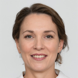 Joyful white adult female with medium  brown hair and grey eyes