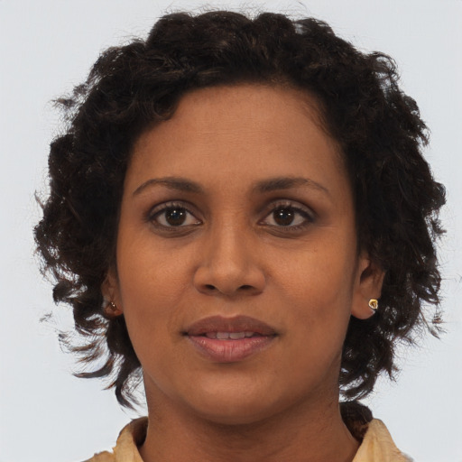 Joyful black young-adult female with medium  brown hair and brown eyes