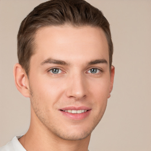 Joyful white young-adult male with short  brown hair and grey eyes