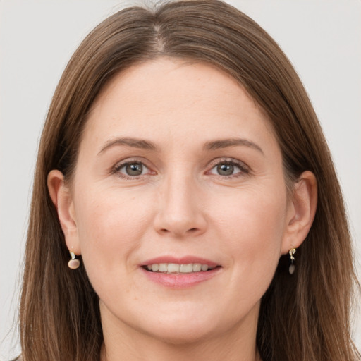 Joyful white young-adult female with long  brown hair and grey eyes