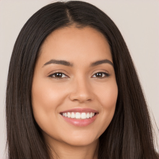 Joyful latino young-adult female with long  brown hair and brown eyes