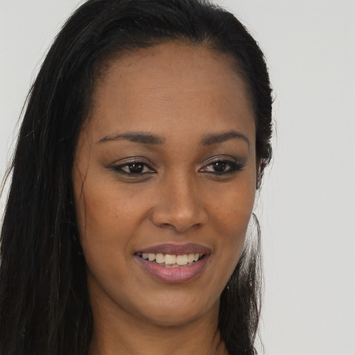 Joyful black young-adult female with long  brown hair and brown eyes