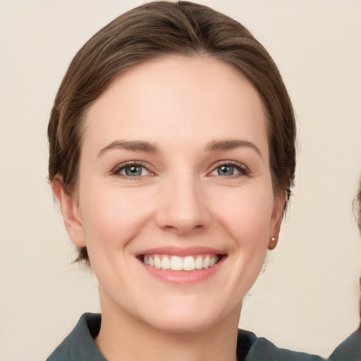 Joyful white young-adult female with medium  brown hair and grey eyes