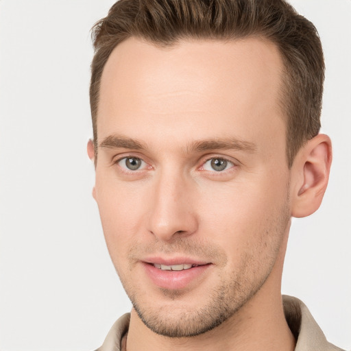 Joyful white young-adult male with short  brown hair and grey eyes