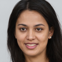 Joyful latino young-adult female with long  brown hair and brown eyes