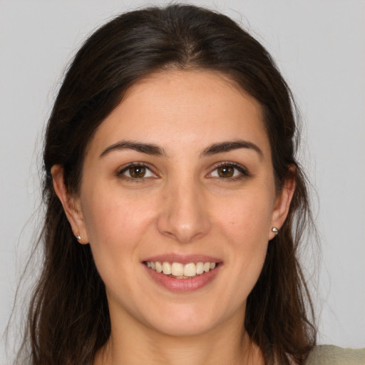 Joyful white young-adult female with long  brown hair and brown eyes