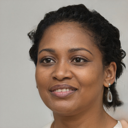 Joyful black young-adult female with medium  black hair and brown eyes