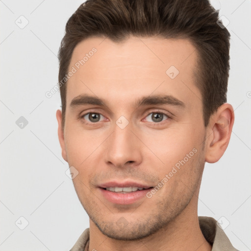 Joyful white young-adult male with short  brown hair and brown eyes