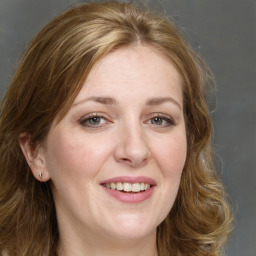 Joyful white adult female with long  brown hair and green eyes